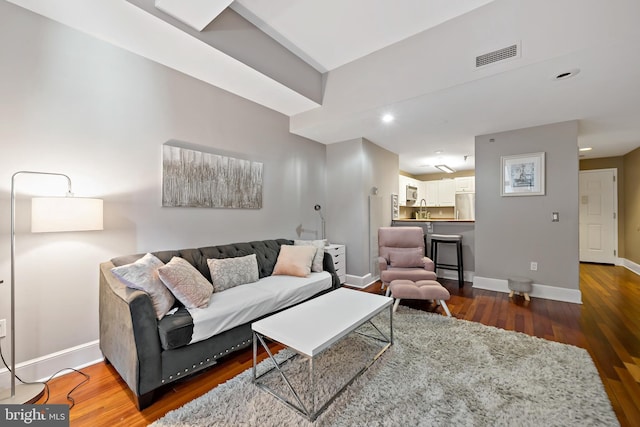 living room with dark hardwood / wood-style flooring and sink