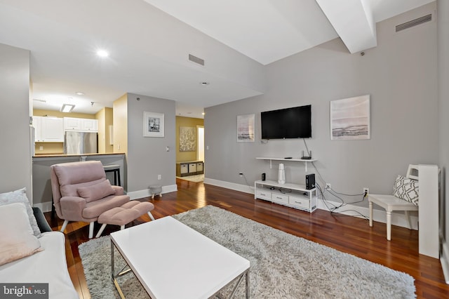 living room with beamed ceiling and dark hardwood / wood-style floors