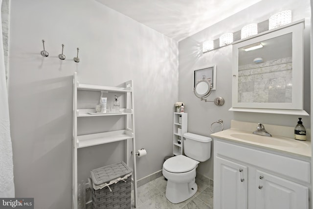 bathroom featuring tile patterned floors, vanity, and toilet