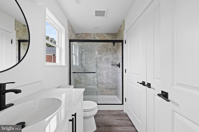 bathroom with vanity, toilet, visible vents, and a stall shower