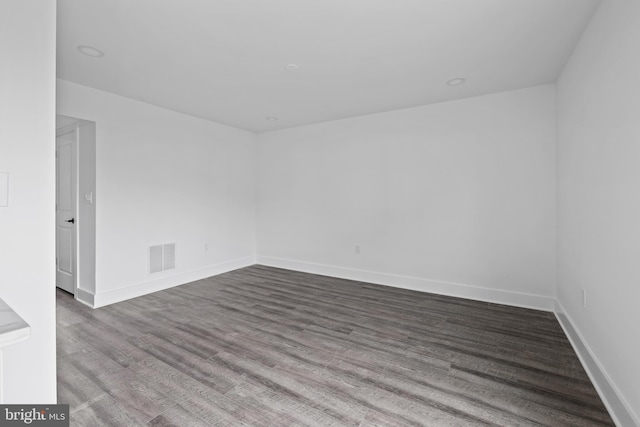 unfurnished room with recessed lighting, visible vents, baseboards, and dark wood-style flooring