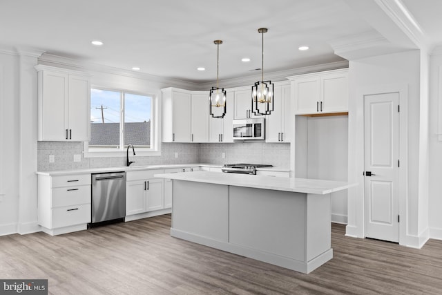 kitchen with appliances with stainless steel finishes, light countertops, and white cabinetry