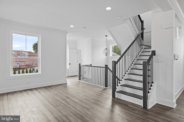 stairway featuring plenty of natural light, baseboards, and wood finished floors