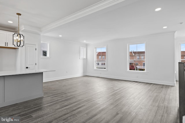 unfurnished living room with ornamental molding, an inviting chandelier, baseboards, and dark wood-style flooring