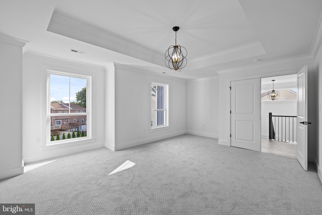 unfurnished room featuring an inviting chandelier, a raised ceiling, and light colored carpet