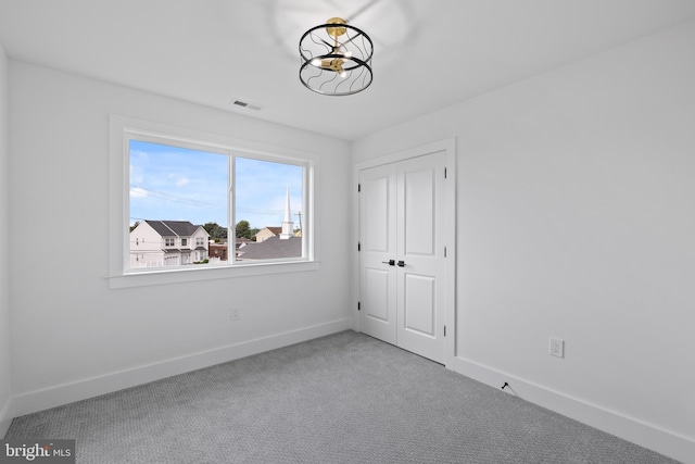 interior space featuring visible vents, carpet floors, baseboards, and a closet