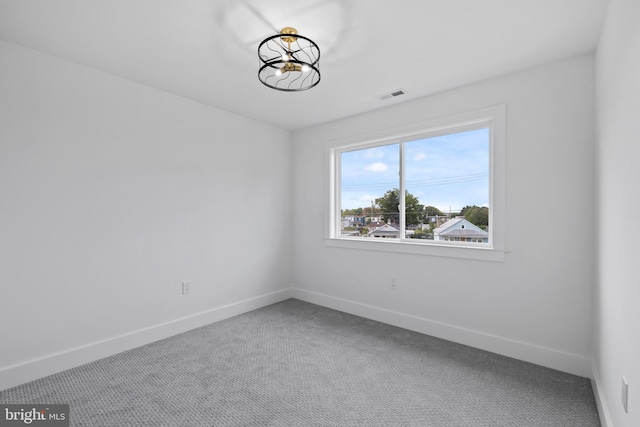 carpeted empty room featuring visible vents and baseboards