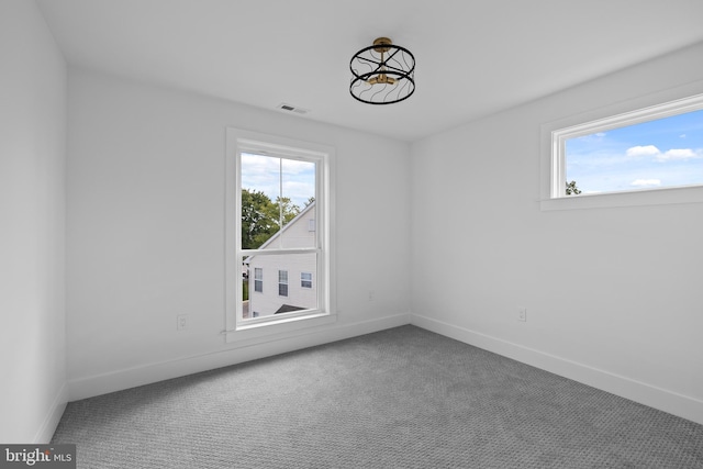 unfurnished room with carpet flooring, plenty of natural light, baseboards, and visible vents