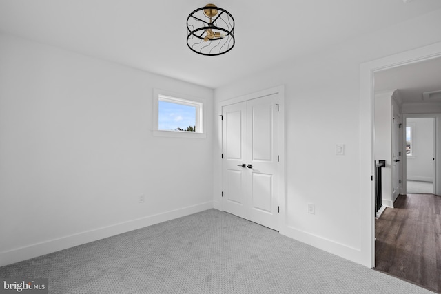 unfurnished bedroom with carpet flooring, baseboards, and a closet