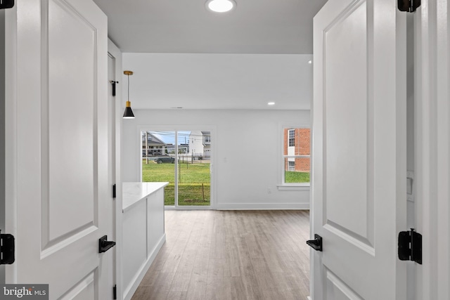 corridor with recessed lighting, light wood-style flooring, and baseboards