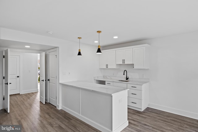 kitchen featuring baseboards, dark wood finished floors, recessed lighting, a sink, and white cabinetry