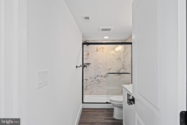 bathroom with toilet, wood finished floors, visible vents, and a marble finish shower