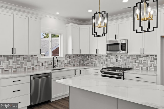 kitchen with visible vents, a sink, appliances with stainless steel finishes, crown molding, and a chandelier