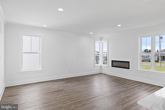 unfurnished living room with baseboards, a fireplace, ornamental molding, and dark wood-style flooring