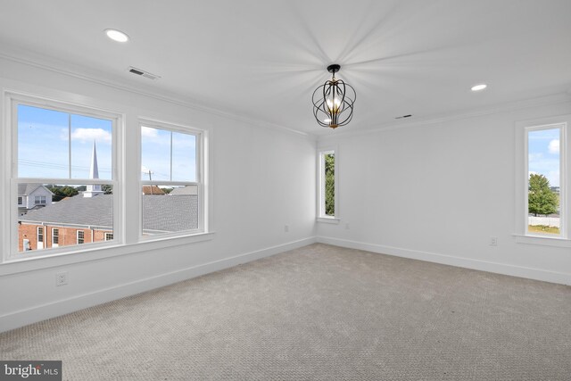 unfurnished room featuring visible vents, ornamental molding, carpet floors, an inviting chandelier, and baseboards