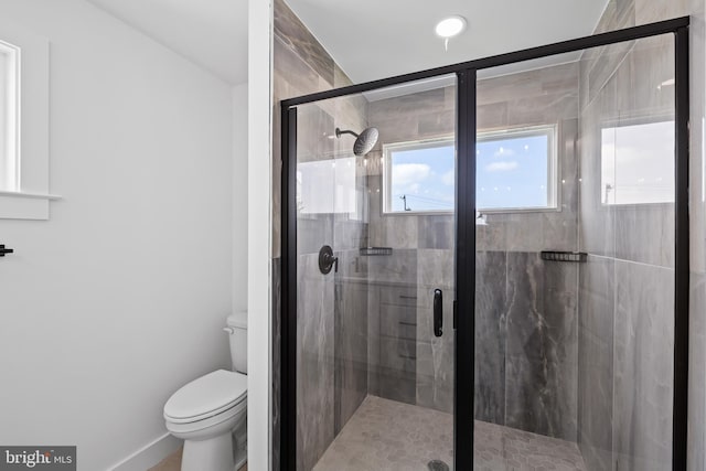 bathroom with a shower stall and toilet