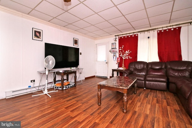 living room featuring dark hardwood / wood-style floors, a drop ceiling, and ornamental molding