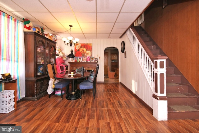 dining room featuring a chandelier, dark hardwood / wood-style flooring, and a drop ceiling