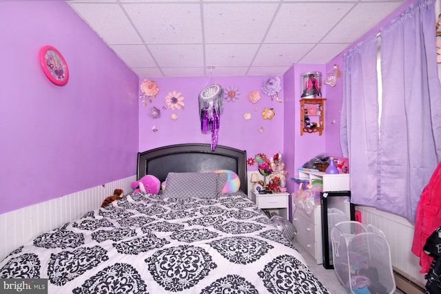 bedroom featuring baseboard heating and a drop ceiling