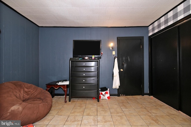 sitting room featuring light tile patterned flooring and wood walls