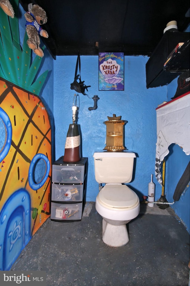 bathroom with concrete floors and toilet