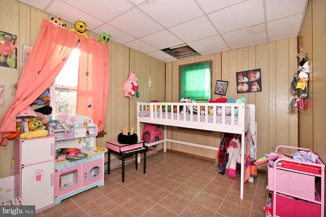 bedroom with wood walls and a drop ceiling