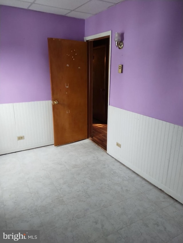 unfurnished room featuring a drop ceiling