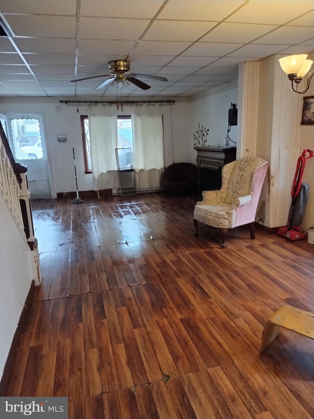 interior space featuring a paneled ceiling, ceiling fan, and dark wood-type flooring