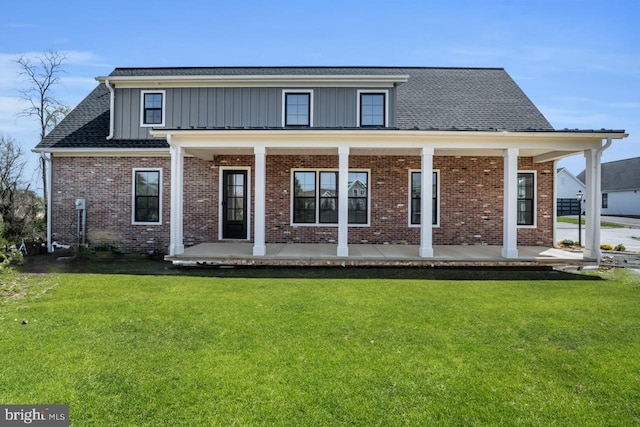 back of property with covered porch and a lawn