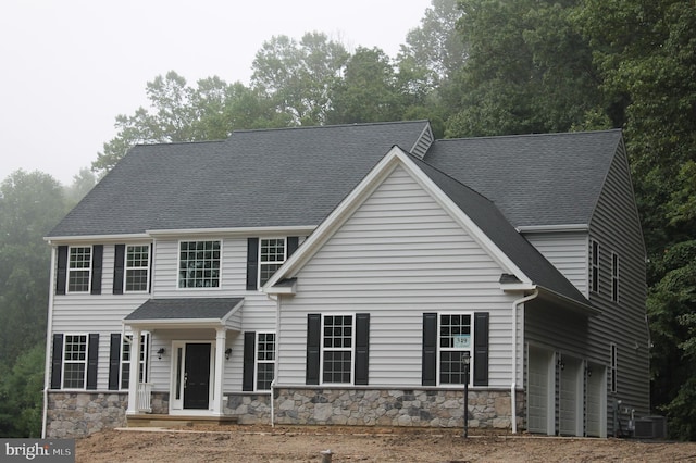 view of front facade with a garage and cooling unit