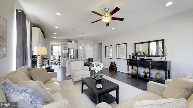 living room featuring ceiling fan and dark wood-type flooring