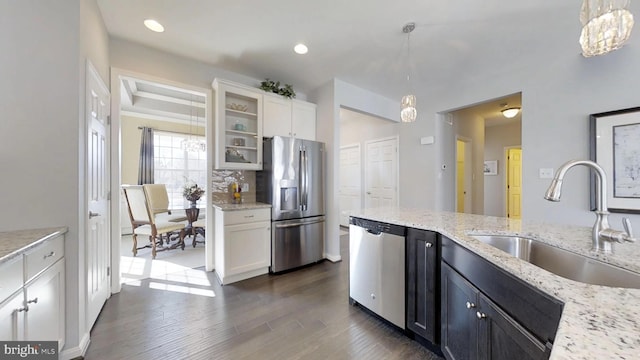 kitchen featuring pendant lighting, stainless steel appliances, white cabinetry, and sink