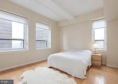 bedroom with beamed ceiling and multiple windows