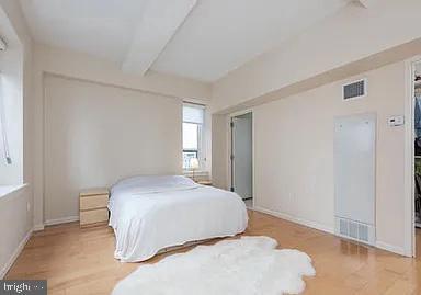 bedroom featuring beam ceiling and light hardwood / wood-style flooring