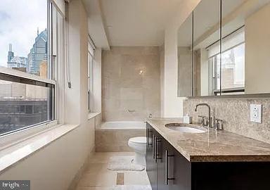 full bathroom with tile patterned flooring, vanity, plenty of natural light, and toilet