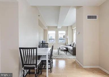 dining space featuring light hardwood / wood-style flooring and beamed ceiling