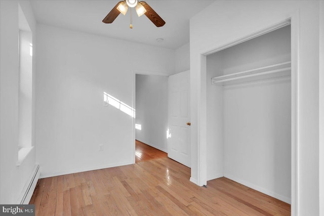 unfurnished bedroom featuring light hardwood / wood-style floors, baseboard heating, a closet, and ceiling fan