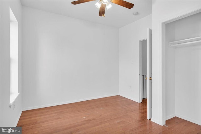 unfurnished bedroom with a closet, wood-type flooring, and ceiling fan