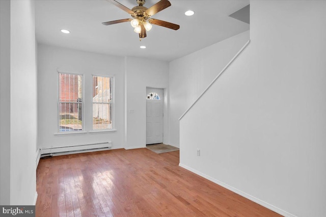 foyer entrance featuring light wood-type flooring, ceiling fan, and baseboard heating