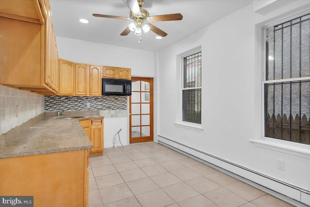 kitchen featuring tasteful backsplash, light tile patterned floors, a baseboard heating unit, ceiling fan, and sink