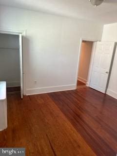 unfurnished bedroom featuring a closet and dark wood-type flooring