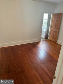 empty room with dark hardwood / wood-style flooring