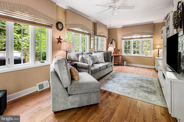 living room featuring visible vents, a ceiling fan, baseboards, and crown molding