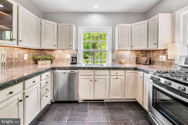 kitchen featuring recessed lighting, tile countertops, tasteful backsplash, a sink, and appliances with stainless steel finishes