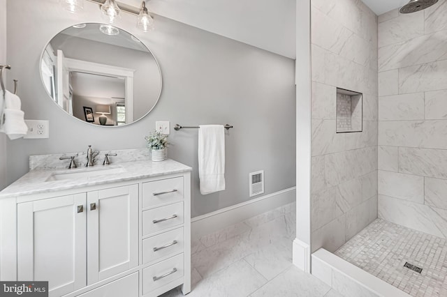 bathroom with visible vents, marble finish floor, a tile shower, and vanity