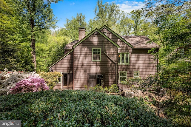 rear view of house featuring a chimney