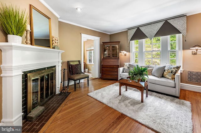 living room featuring plenty of natural light, a fireplace with flush hearth, and crown molding