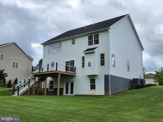 back of property with a lawn, french doors, central AC unit, and a deck