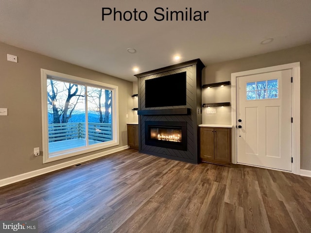 unfurnished living room featuring a fireplace and dark wood-type flooring