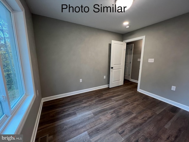 empty room with dark hardwood / wood-style flooring